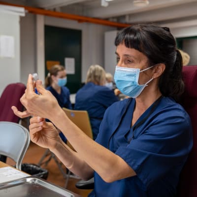 Sairaanhoitaja Linda Aholaita-Pylväs laimentamassa rokotteita käyttövalmiiksi