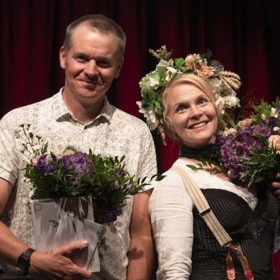 Runoilijat Olli Sinivaara ja Heli Laaksonen kukkakimput käsissään.