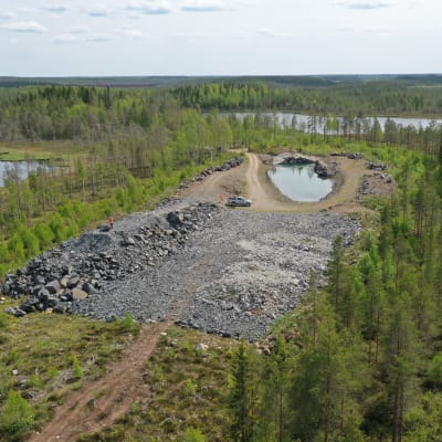En gammal, vattenfylld gruvöppning i landskapet. 