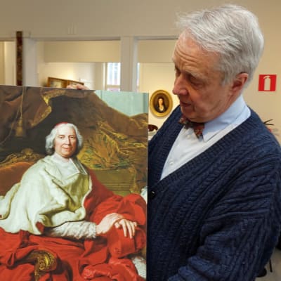 Bernt Morelius hå¨ller upp ett porträtt av kardinal de Fleury