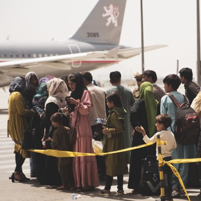 Ihmiset odottavat lentokoneeseen pääsyä Kabulin lentokentällä. 