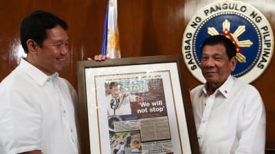 President Rodrigo Duterte (tv) emottar en dagstidnings förstasida där det står, Vi kommer inte att stoppa - en hänvvisning till Duertes omstridda kampanj Skjut för att döda