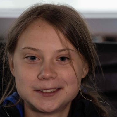 En närbild på en leende Greta Thunberg.