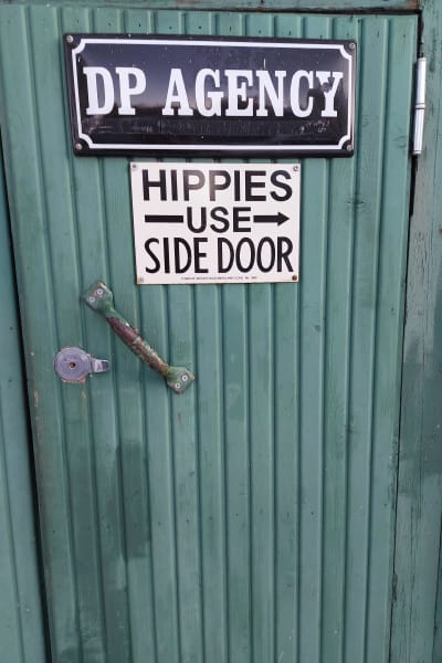 Dörr där det står att hippies ska ta sidodörren.