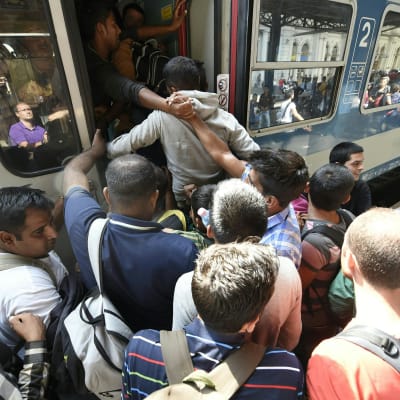 Flyktingar stiger ombord tåg i Budapest.