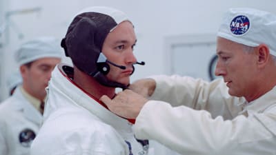 Buzz Aldrin får dräkten justerad.