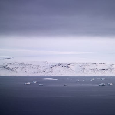 Merta Grönlannin länsipuolella, vastarannalla lumipeitteistä maata.