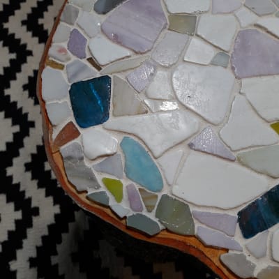 Ytan på mosaikstubbe med mosaik som är fästa med lim på bordsytan.
