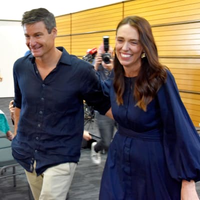 Jacinda Ardern poistuu puolisonsa kanssa lehdistötilaisuudesta.