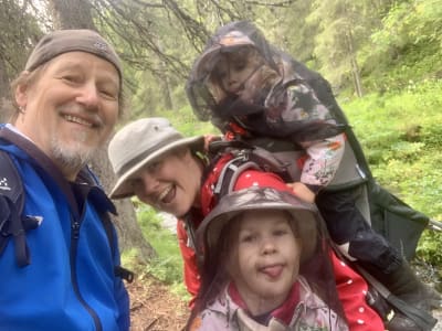 Jan Stenfors tillsammans med sin fru och sina två döttrar ute i skogen. Familjen är klädd i myggnät och friluftskläder.