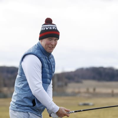 Patrik Laine står med en golfklubba i handen.
