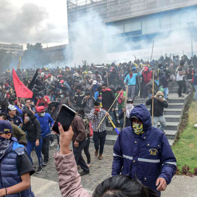 Tårgas och demonstranter utanför parlamentsbyggnaden i Ecuadors huvudstad Quito den 8 oktober 2019.