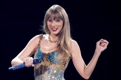 Taylor Swift på scen med mikrofon i handen.