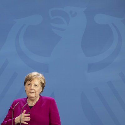 Angela Merkel takanaan seinällä Saksan vaakunaeläin kotka