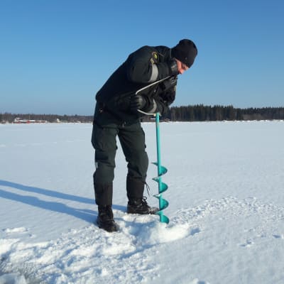 Sjöbevakningsmästare Michael Nordlund testar isens tjocklek utanför Vallgrunds sjöbevakningsstation.