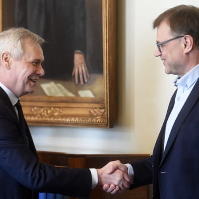 Antti Rinne och Juha Sipilä skakar hand.