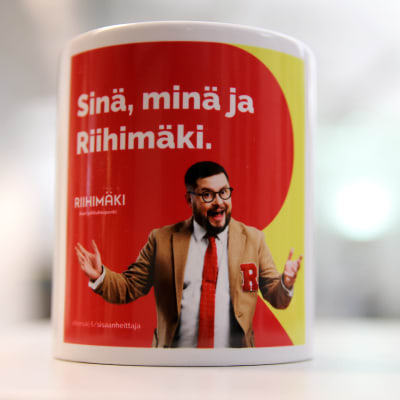 Riihimäen kaupungin mainosmuki, jonka punakeltaisella pohjalla Janne Katajan esittämä Sisäänheittäjä.