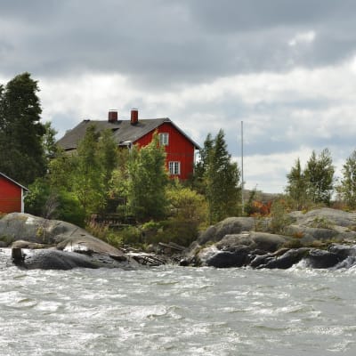Tre sommarstugor vid vattnet.