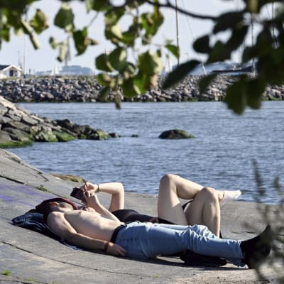 Solande par på en klippa vid havet i Helsingfors. 