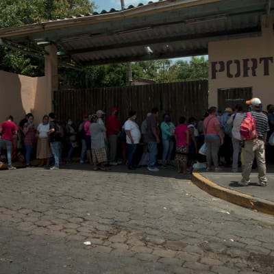 Människor utanför en sjukhusport i Managua.