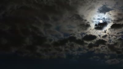 Natthimmel med moln och fullmåne.  