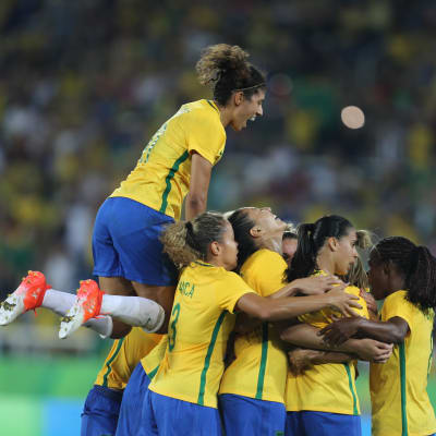 Brasiliens damlandslag i fotboll firar ett mål mot Sverige tillsammans.