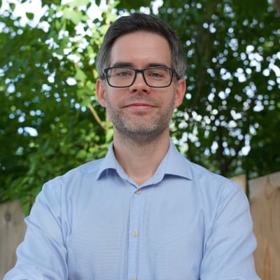 En man står med korsade armar.