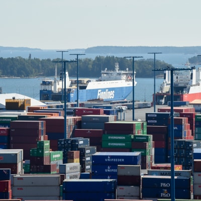 Vy över Nordsjö hamn med containrar i förgrunden och skärgård och fraktfartyg i bakgrunden.