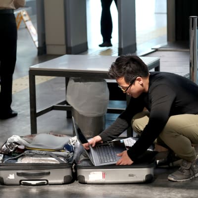 Passagerare på Atatürkflygplatsen i Istanbul placerar sin laptop i den incheckade bagaget.