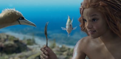Sjöjungfrun håller upp en gaffel inför en fisk och en mås.