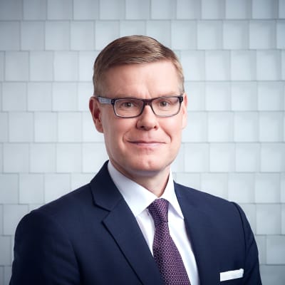 Man med glasögon iklädd kostym.