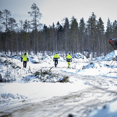 Kolme miestä kävelee Keliberin kaivostyömaalla. 