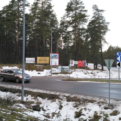 bil i vägkorsning med reklamskyltar 