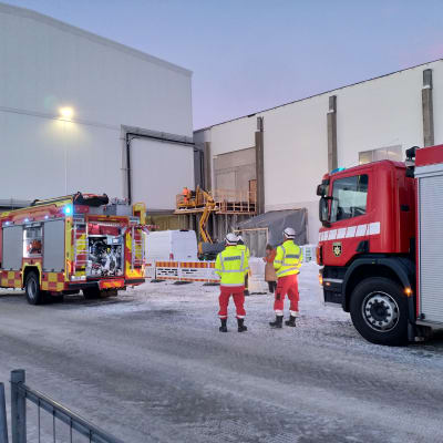 Brandbilar utanför en fabriksbyggnad.