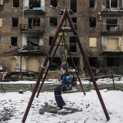 Lapsi keinuu ilmahyökkäyksessä tuhoutuneen asuintalon pihassa Ukrainan Vyšhorodissa. 