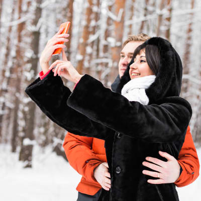 Ett par tar en selfie i en snöig omgivning.
