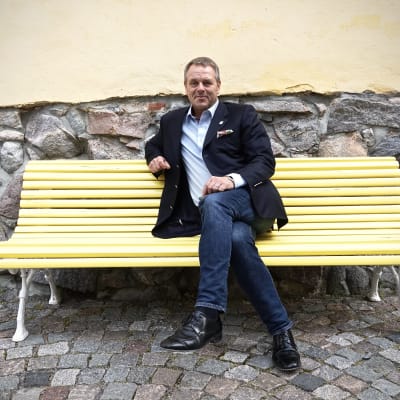 Jan Vapaavuori istuu penkillä Helsingin kaupungintalon sisäpihalla.