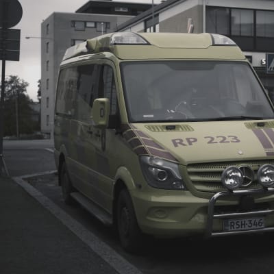 En ambulans står parkerad på gatan.