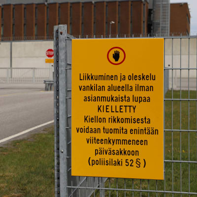 Bild från porten till Åbo fängelse med en gul skylt till vänster där det står att obehöriga inte har tillträde. 