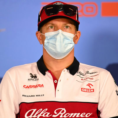 Kimi Räikkönen blickar uppåt med munskydd på sig.