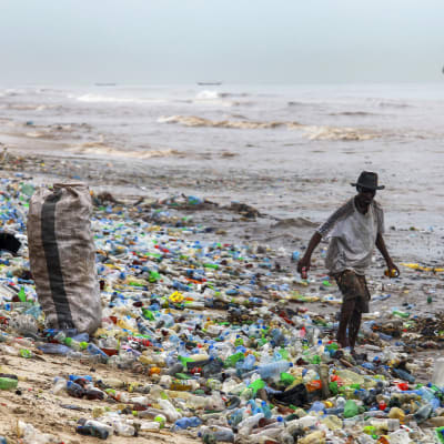 a Ghanaian collecting recyclable material at the polluted Korle Gono beach, that is covered in plastic bottles and other items washed ashore, following weeks of heavy flooding in Accra, Ghana 12 June 2016. The recyclable materials were washed from the cap