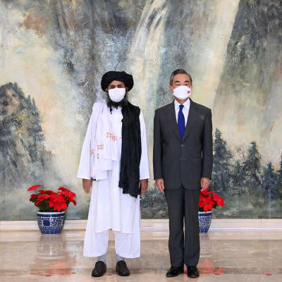 Talebanin edustaja Mullah Abdul Ghani Baradar tapaamassa Kiinan ulkoministeriä Wang Yitä.