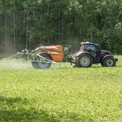 Traktori ruiskuttaa torjunta-aineita etelä-hämäläisellä pellolla