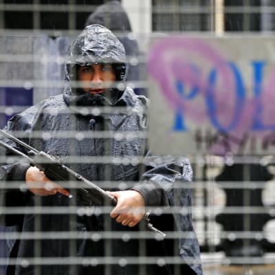 En turkisk polis patrullerar med maskinpistol i regnet i Istanbul.
