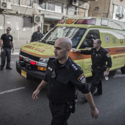 En palestinier förs bort i ambulans efter att ha knivhuggit en israelisk soldat till döds i Tel Aviv.