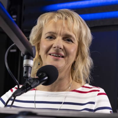 Camilla Andelin bakom mikrofonen i en radiostudio.