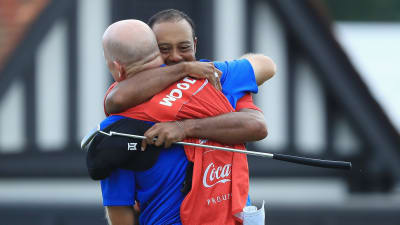 Tiger Woods omfamnar sin caddie Joe LaCava.