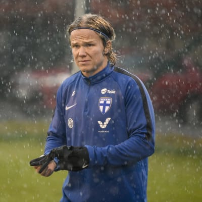 Petteri Forsell står på en fotbollsplan i regnet iklädd landslagets kläder.