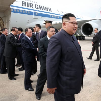 Nordkoreas ledare Kim Jong-Un med följe, efter att de landat på flygplatsen i Singapore.