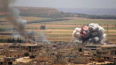 Rök stiger upp när regeringstyrkor beskjuter staden Khan Sheiktun i södra Idlib.